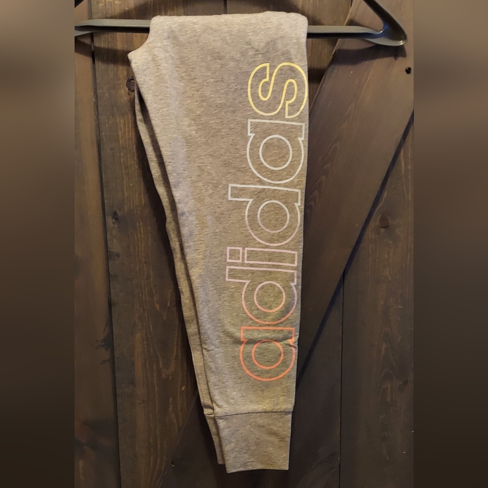 Girls ankle length leggings. Gray with pastel color logo down one leg. NWT